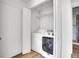 A modern laundry room equipped with a washer, dryer, and overhead shelving at 15805 W 14Th Pl, Golden, CO 80401
