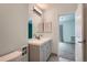 Bright bathroom featuring a modern vanity with a sleek countertop and a view into the bedroom at 2504 S Victor St # E, Aurora, CO 80014