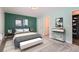 Comfortable bedroom with stylish decor, green accent wall and plenty of natural light at 2504 S Victor St # E, Aurora, CO 80014