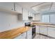 Bright kitchen featuring butcher block countertops, white cabinets, and stainless steel appliances at 2504 S Victor St # E, Aurora, CO 80014