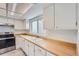 White kitchen featuring a stainless steel range and butcher block countertops at 2504 S Victor St # E, Aurora, CO 80014