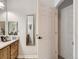 Bathroom features a mirror, vanity with counter space, and convenient closet access at 5755 N Genoa Way # 14-105, Aurora, CO 80019