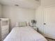 Cozy bedroom with a bed, white comforter, lamp, and minimalist decor at 5755 N Genoa Way # 14-105, Aurora, CO 80019