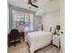 Comfortable bedroom with a ceiling fan, desk, and large window with natural light at 5755 N Genoa Way # 14-105, Aurora, CO 80019
