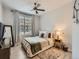 Bright bedroom features a ceiling fan, large window, and a comfortable bed at 5755 N Genoa Way # 14-105, Aurora, CO 80019