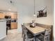 Open dining area with stylish table, chairs, booth, and adjacent kitchen at 5755 N Genoa Way # 14-105, Aurora, CO 80019