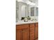 Double sink bathroom vanity featuring wood cabinets and a large mirror at 4063 Castle Vista Dr, Castle Rock, CO 80104