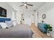 Tastefully decorated bedroom featuring a blue headboard, ceiling fan, and a view into the ensuite bathroom at 4063 Castle Vista Dr, Castle Rock, CO 80104