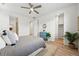 Bright bedroom showcasing a blue headboard, ceiling fan, and a glimpse of the ensuite bathroom at 4063 Castle Vista Dr, Castle Rock, CO 80104