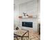 A modern fireplace design featuring a light-tiled wall, sleek black fireplace insert, and a wooden mantle at 4063 Castle Vista Dr, Castle Rock, CO 80104