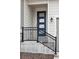 Close up of the front door with a black metal handrail and a modern glass paneled door at 4063 Castle Vista Dr, Castle Rock, CO 80104