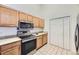Well-equipped kitchen with stainless steel appliances, wood cabinetry, and tile flooring at 12288 W Dorado Pl # 301, Littleton, CO 80127