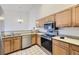 Bright kitchen featuring stainless steel appliances, wood cabinets, and a tile backsplash at 12288 W Dorado Pl # 301, Littleton, CO 80127