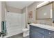 Bathroom showcasing a bath and shower, blue vanity, modern mirror, and tile floors at 1820 Newland Ct # 201, Lakewood, CO 80214
