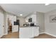 Contemporary kitchen featuring white cabinetry, modern appliances, and access to the bathroom at 1820 Newland Ct # 201, Lakewood, CO 80214