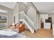 Open-concept living room showcasing hardwood floors, a staircase, and access to the kitchen and other areas at 1820 Newland Ct # 201, Lakewood, CO 80214