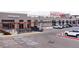 The exterior of a public market showcasing a variety of shops with ample parking at 1820 Newland Ct # 201, Lakewood, CO 80214