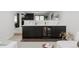 Stylish basement bar boasts marble countertops, sleek black cabinets, sink and wine refrigerator at 5516 S Havana Ct, Englewood, CO 80111