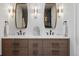 Elegant bathroom featuring a double sink vanity with wood cabinets and modern lighting fixtures at 5516 S Havana Ct, Englewood, CO 80111