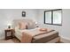Cozy bedroom with neutral walls, large window, plush bedding, and tasteful bedside decor at 5516 S Havana Ct, Englewood, CO 80111