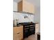 A modern kitchen with a black gas range, sleek countertops, and neutral-toned cabinets at 5516 S Havana Ct, Englewood, CO 80111
