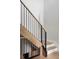 Staircase with black metal railings and wood steps, showcasing modern design and craftsmanship at 5516 S Havana Ct, Englewood, CO 80111