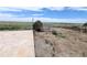 Backyard area with gravel and weeds. Building in background at 11897 Roxburg St, Strasburg, CO 80136