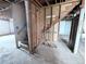 Basement with stairwell and exposed unfinished framing and concrete floors at 11897 Roxburg St, Strasburg, CO 80136