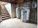 Unfinished basement with hot water tank and stairs at 11897 Roxburg St, Strasburg, CO 80136