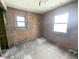 Interior shot of a bedroom with wood paneling and two windows at 11897 Roxburg St, Strasburg, CO 80136