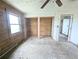 Bedroom with wood walls and open closets at 11897 Roxburg St, Strasburg, CO 80136