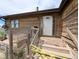 Close-up of the home's entrance, featuring a wooden porch and traditional door at 11897 Roxburg St, Strasburg, CO 80136