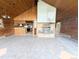 Open-concept living room featuring wood walls, tile flooring, a fireplace, and a view of the kitchen at 11897 Roxburg St, Strasburg, CO 80136