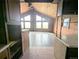 Rustic living room with wood walls, vaulted ceilings, tile flooring, and large windows overlooking the scenic outdoors at 11897 Roxburg St, Strasburg, CO 80136