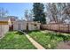 View of the backyard with grass lawn and storage sheds near a wooden fence at 424 S Pennsylvania St, Denver, CO 80209