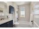Updated bathroom featuring subway tiles, a vanity with gold hardware, and a shower/tub combination with a window at 424 S Pennsylvania St, Denver, CO 80209
