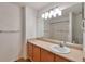 Bright bathroom featuring a large mirror, neutral countertop, wood cabinets, and a shower and tub at 20308 E 46Th Ave, Denver, CO 80249