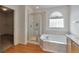 Bright bathroom features a tub, separate shower, and decorative glass window at 20308 E 46Th Ave, Denver, CO 80249