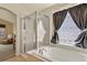 Bright bathroom features a tub, shower, and glass block window that provides natural light and privacy at 20500 E Hamilton Ave, Aurora, CO 80013