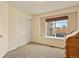 Spare bedroom features a closet, desk, large window for natural light, and neutral carpet at 20500 E Hamilton Ave, Aurora, CO 80013