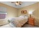 Cozy bedroom with floral bedding, natural light, ceiling fan, and a wooden bedside table at 20500 E Hamilton Ave, Aurora, CO 80013