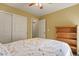 Bedroom boasts floral bedding, a ceiling fan, and natural light with a closet and bookshelf at 20500 E Hamilton Ave, Aurora, CO 80013