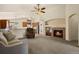 Spacious living room featuring a fireplace, ceiling fan and an open floorplan flowing into the kitchen at 20500 E Hamilton Ave, Aurora, CO 80013