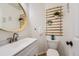 This bathroom features a modern sink, round mirror, and stylish decor at 9879 Sydney Ln, Highlands Ranch, CO 80130