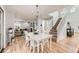 Bright dining area with hardwood floors, a view into the living room and an adjacent staircase to the second floor at 9879 Sydney Ln, Highlands Ranch, CO 80130