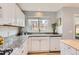 Well-lit kitchen featuring white cabinetry, granite countertops, white subway tile backsplash, and a stainless steel sink at 9879 Sydney Ln, Highlands Ranch, CO 80130