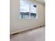 Bedroom with neutral carpet and white walls, featuring a large window with a view of the neighborhood at 457 Interlocken Blvd # 105, Broomfield, CO 80021