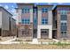 Modern townhouse with brick and siding exterior, showcasing the front entrance and landscaping at 457 Interlocken Blvd # 105, Broomfield, CO 80021