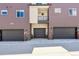 Three-story townhouse exterior with three garage doors and a small balcony at 457 Interlocken Blvd # 105, Broomfield, CO 80021