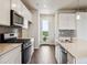 Modern kitchen featuring white cabinets, stainless steel appliances, and a stylish tile backsplash at 457 Interlocken Blvd # 105, Broomfield, CO 80021